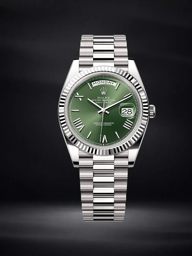 Rolex Day-Date watch with a green dial and silver-tone bracelet on a deep navy background.