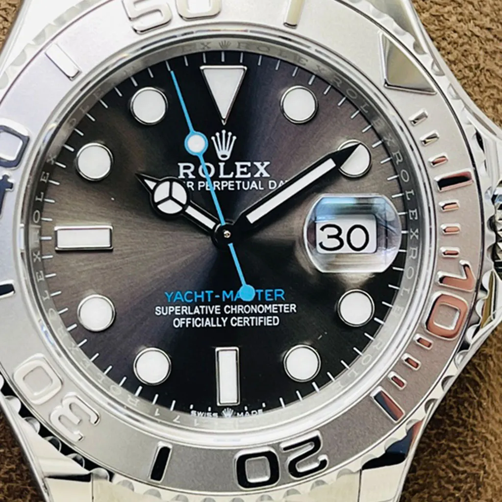 Rolex Yacht-Master close-up with a rhodium dial, blue seconds hand, date magnifier showing 30, and silver bezel.