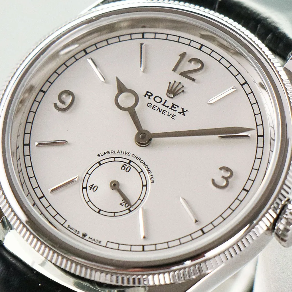 Rolex white dial small seconds wristwatch close up with Arabic numerals and polished stainless steel bezel