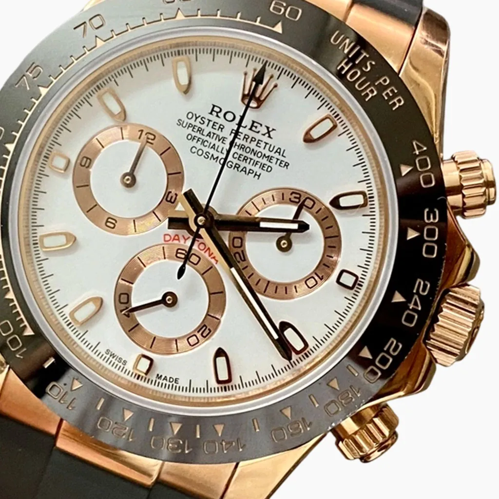 Rolex Daytona chronograph watch with white dial, rose gold subdials, black tachymeter bezel, and black rubber strap