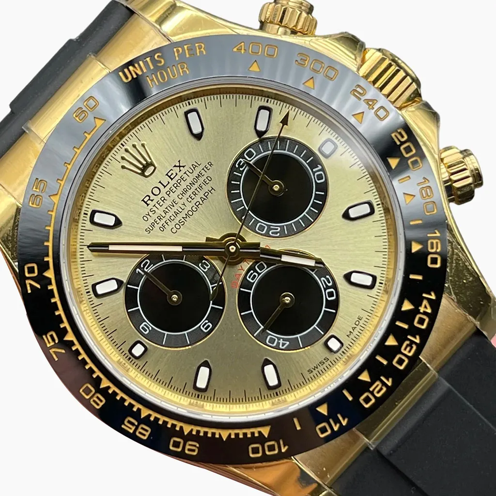 Daytona luxury chronograph watch with champagne gold dial, black subdials, black tachymeter bezel, gold case, and rubber strap