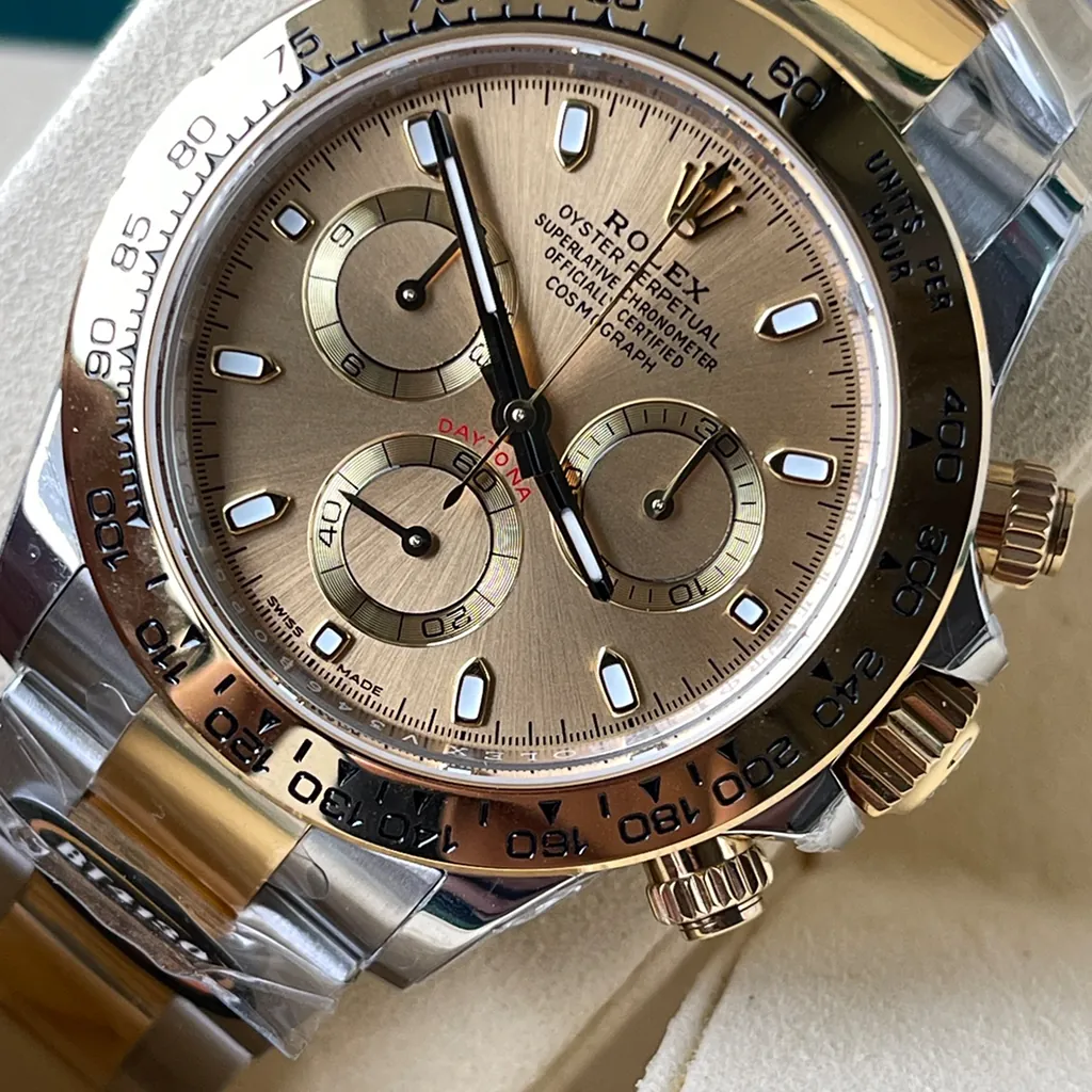 Rolex Cosmograph Daytona two-tone watch with champagne dial and gold tachymeter bezel.