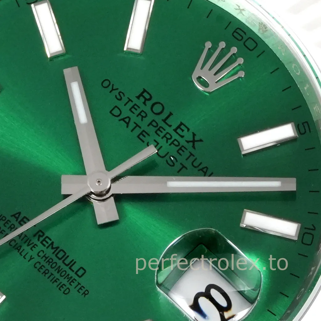 Close-up of an AET Remould Rolex Datejust with a green dial, luminous baton markers, silver hands, and Cyclops date window.
