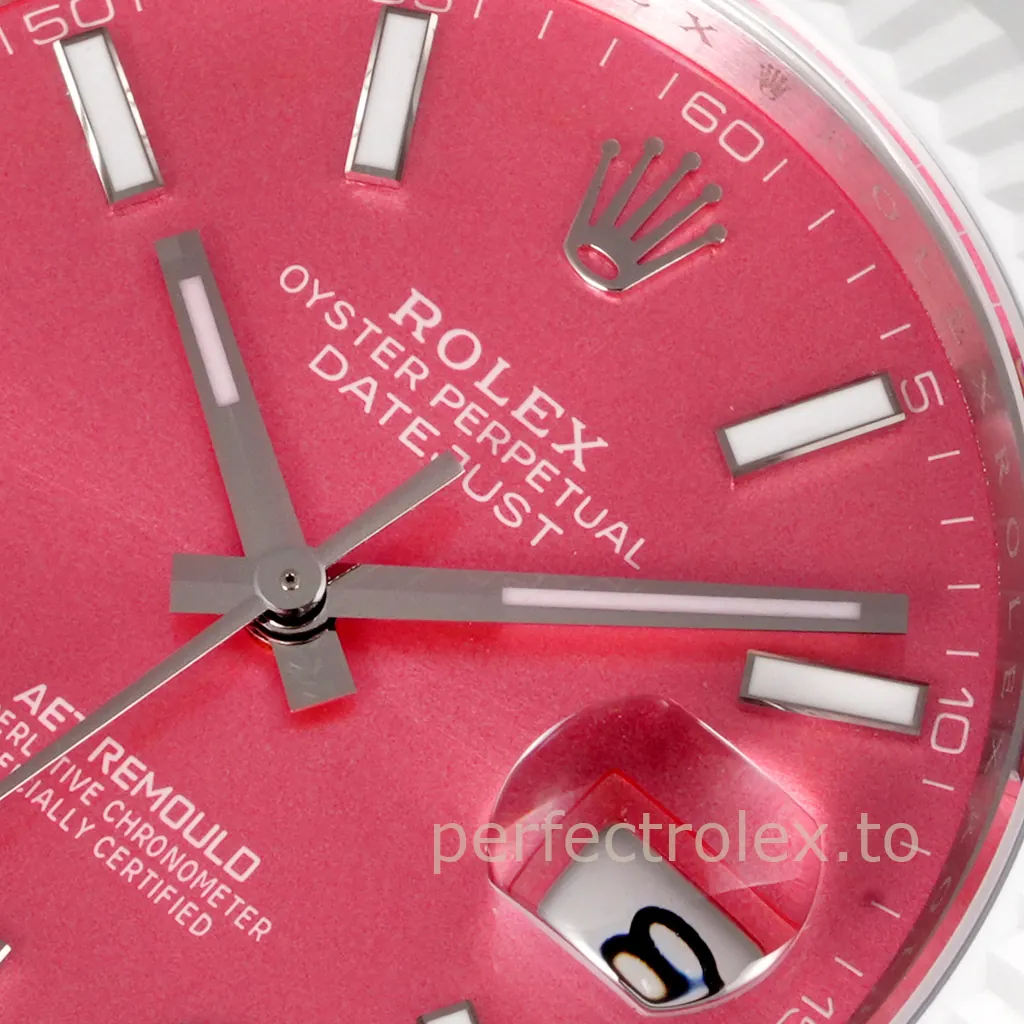 Close-up of an AET Remould Rolex Datejust with a pink dial, luminous baton markers, silver hands, and Cyclops date window.