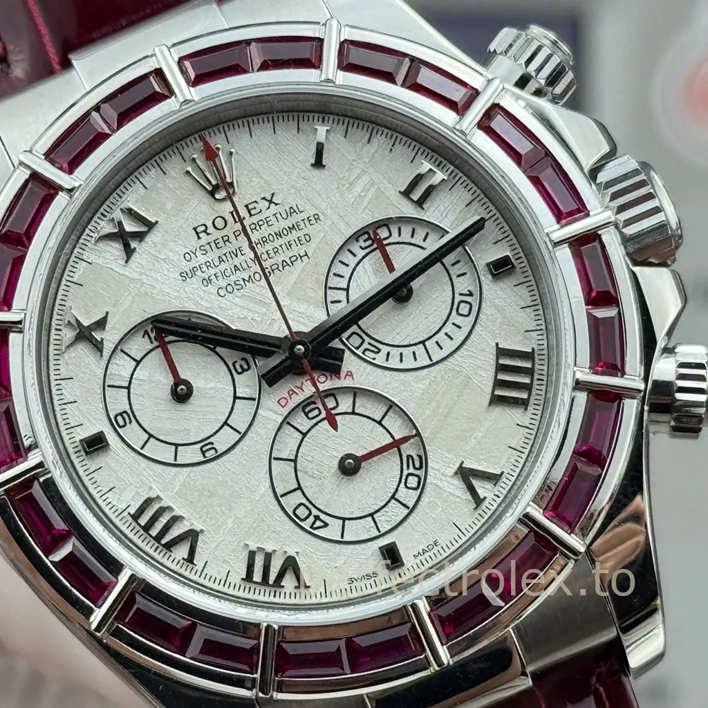 Rolex Cosmograph Daytona with a textured white dial, black Roman numeral markers, ruby baguette bezel, red chronograph hands and burgundy leather strap.